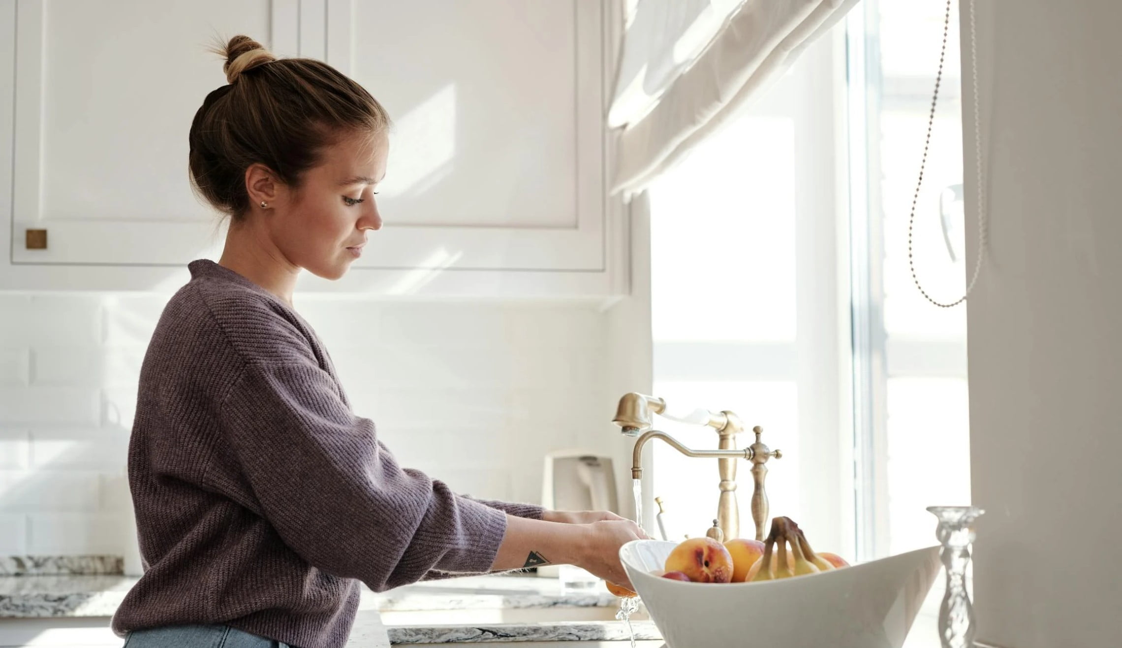 Woman washing fruit in a sink