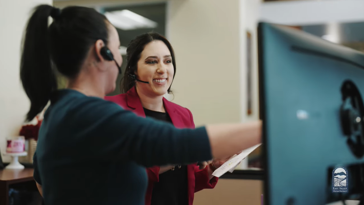 Image of 2 employees looking at a computer monitor, click to open modal window with video